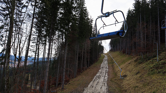 乌克兰，Bukovel - 2019 年 11 月 20 日。在秋季山坡和冬季滑雪胜地建设中的基础设施背景下，带缆车的滑雪胜地的秋季景色。