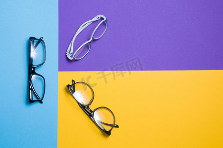彩色背景上的几副眼镜、顶视图、购买眼镜、眼镜店和眼镜框、儿童眼镜和成人眼镜