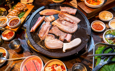 韩国餐厅的煎熟黑猪肉餐，铁盘上新鲜美味的韩国菜配生菜，特写，复制空间，生活方式