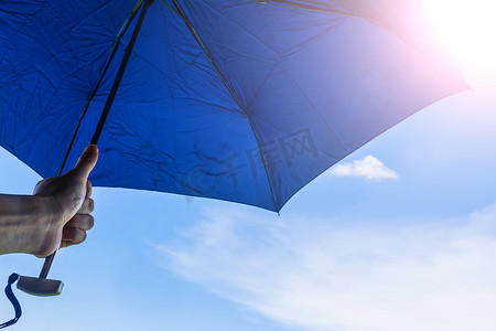 手撑伞有蓝天和阳光背景