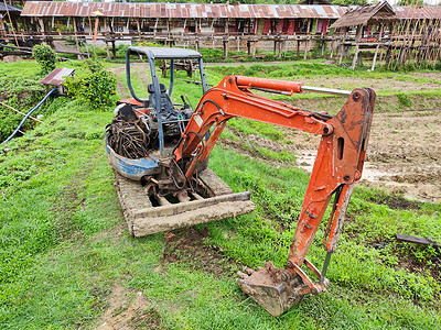 泰国稻田中破旧的黄色挖掘机。