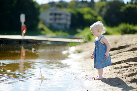 石头可爱摄影照片_可爱的女孩往河里扔石头