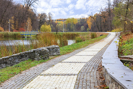 铺有鹅卵石叶子框架的铺路板进入城市秋季公园