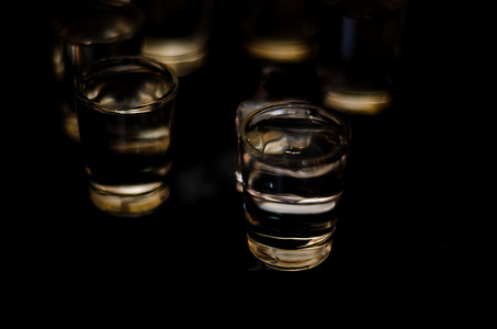 黑色背景玻璃杯中的传统纯伏特加，冰镇饮料
