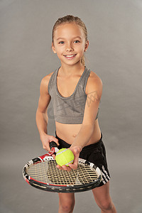拿着网球拍和球的快乐的女孩