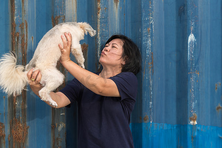亚洲女人和狗高兴地拥抱着容器