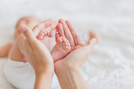 招标反腐摄影照片_母亲抱着刚出生的婴儿的赤脚。