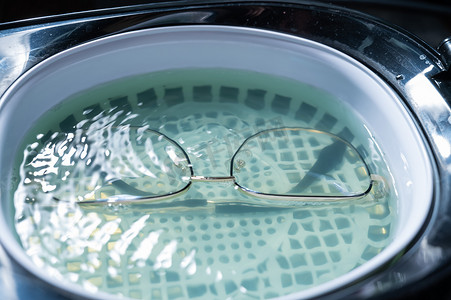 消毒摄影照片_溶液中眼镜的超声清洗。