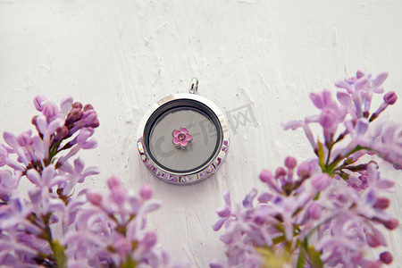 闪亮的银色项链，适合女士，靠近紫丁香花。