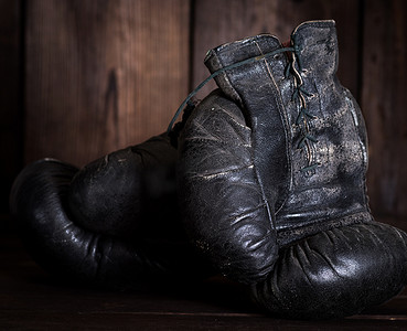 一双非常旧的破旧黑色皮革拳击手套