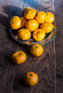 餐桌上的水果摄影照片_乡村餐桌上的成熟橘子