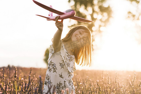 肖像快乐的孩子与玩具飞机在夏季天空背景。