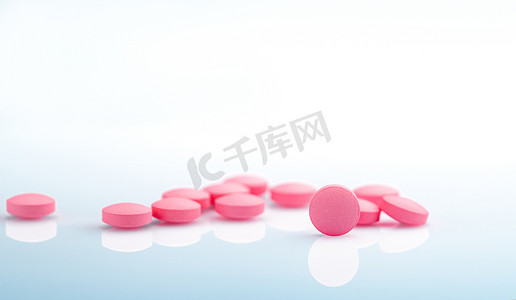 白色背景上的圆形粉红色药片。