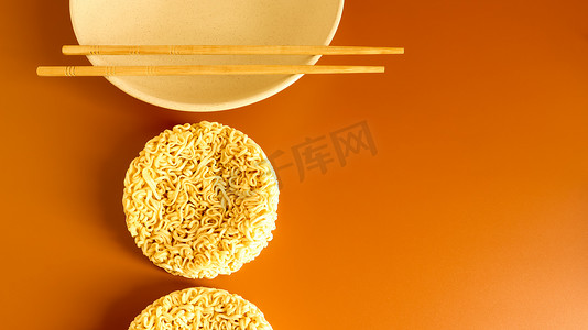 筷子上的面摄影照片_用筷子在盘子上呈典型圆形的干方便面。