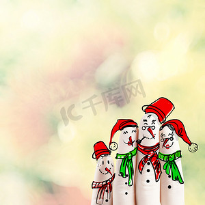 可爱手绘雪人摄影照片_一个可爱的家庭手绘和自然背景上的雪人手指