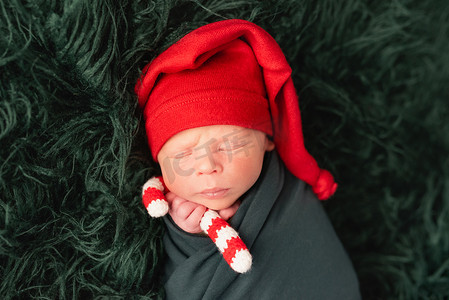 圣诞宝宝摄影照片_戴着红色圣诞帽睡觉的可爱宝宝