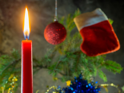 圣诞派礼摄影照片_圣诞红蜡烛在冷杉树枝的背景下燃烧。