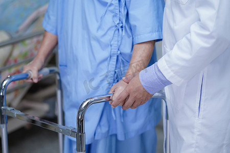 医生在护理医院病房帮助亚洲老年或老年老妇人患者与助行器一起行走。