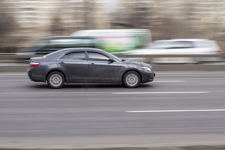 丰田汽车摄影照片_乌克兰，基辅 — 2021年3月18日：灰色丰田凯美瑞汽车在街上行驶。