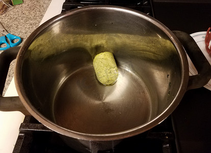 在炉子上的金属锅中冷冻绿色香蒜酱