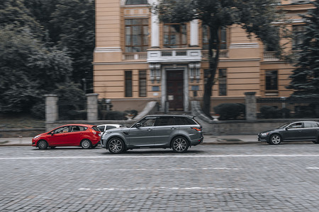 路虎揽胜汽车摄影照片_乌克兰，基辅 - 2021年6月2日：灰色路虎揽胜运动车在街上行驶。