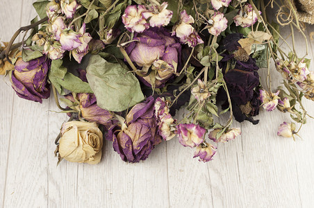 抽象玫瑰花束、旧粗麻布纹理上的干花花束