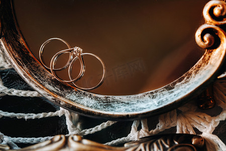 结婚三金摄影照片_两个结婚金戒指订婚戒指的特写镜头。三个戒指。结婚戒指。婚礼