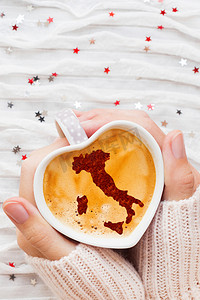 女人拿着一杯热咖啡，里面有意大利的肉桂剪影。