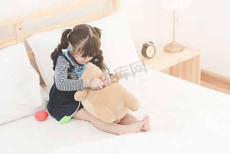 可爱的亚洲小女孩喜欢在家里玩医生玩具套装和可爱的洋娃娃。