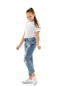 纯白色模板摄影照片_穿着纯白色广告 T 恤和牛仔裤的小女孩。
