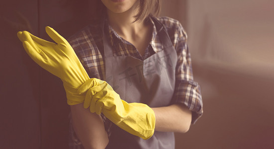 一个戴黄色橡胶手套的女人做家务