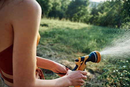 浇树摄影照片_花园乡村夏季农业中浇树的女人