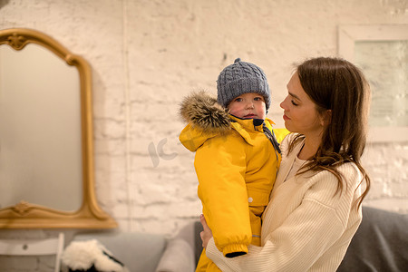 保暖衣物摄影照片_怀里抱着穿着保暖衣服的小孩的母亲