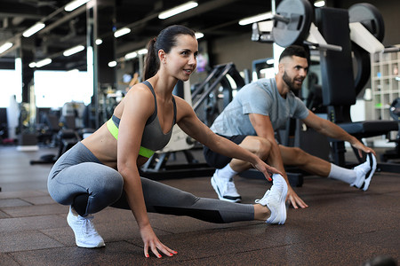 两个健康的人在 crossfit 健身房做伸展运动。
