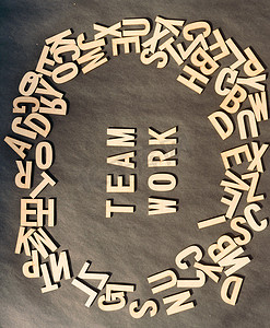 在仿古纸背景上的木制立方体字母表字母顶部视图中的团队工作词。