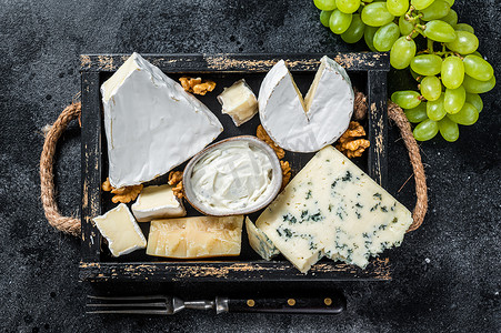 什锦奶酪拼盘，包括布里奶酪、卡门培尔奶酪、羊乳干酪、帕玛森奶酪、蓝奶油奶酪、葡萄和坚果。