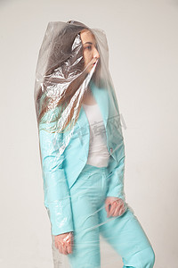灰色背景下塑料袋中的时尚女性