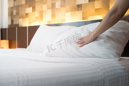 酒店客房服务手在 h 的床上设置白色枕头