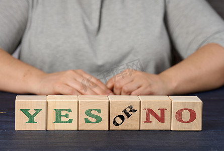 在 nlue 背景上刻有 yes 和 no 字样的木制立方体。
