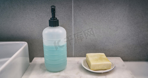 家庭浴室梳妆台横幅背景上洗手产品的皂条与液体洗手皂瓶比较