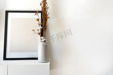 空木照片、带白色花瓶的相框模型和靠近桌上白墙的时尚植物，复制空间现代装饰内饰