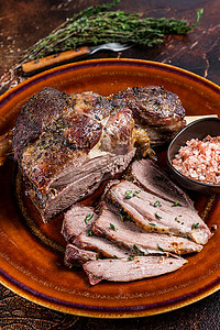 BBQ 烤羊肉腿在质朴的盘子上切片。