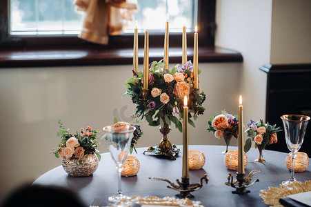 城堡的桌子上有鲜花的婚礼餐桌装饰，烛光晚餐的餐桌装饰。蜡烛晚餐