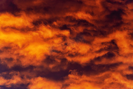 日落时的金色云彩漂浮在天空中紫色和紫色的雷雨云中