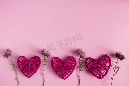 干花摄影照片_粉红色背景中的红心和干花，对大自然的热爱，情人节礼物的天然材料。