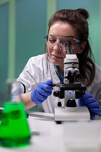 植物学家研究员女性在显微镜下分析转基因叶子样本的肖像