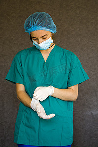 医生或护士的形式、穿医用制服的女性肖像、面具、手套和手术帽