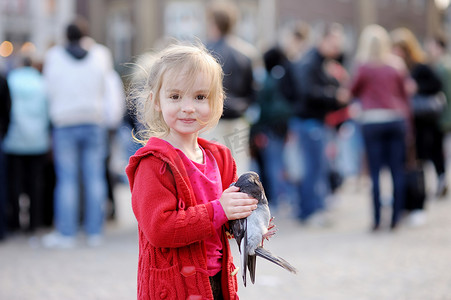 可爱的小女孩抱着一只鸽子