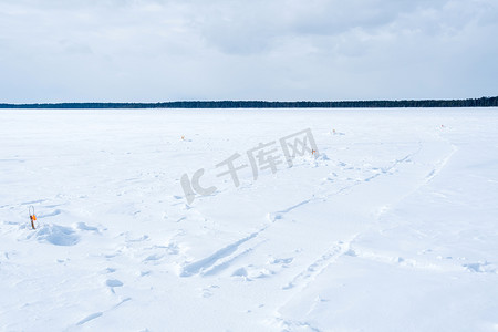在阳光明媚的日子里，在河钓竿的冰面上的冬季景观。