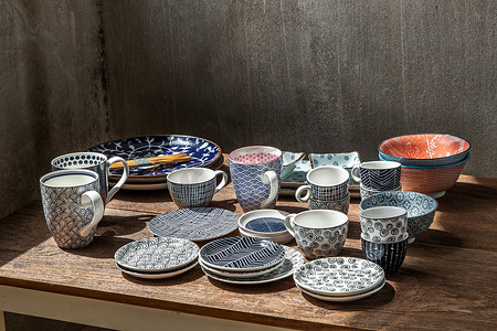 不同的陶瓷盘子、碗和杯子在木桌上。